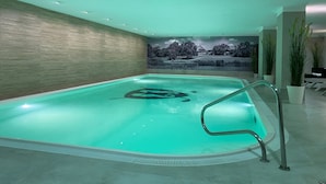 A modern indoor swimming pool with a view of a landscape mural, a wooden wall, and a tiled floor. - Strandgrün Golf- & Spa Resort (Timmendorfer Strand)