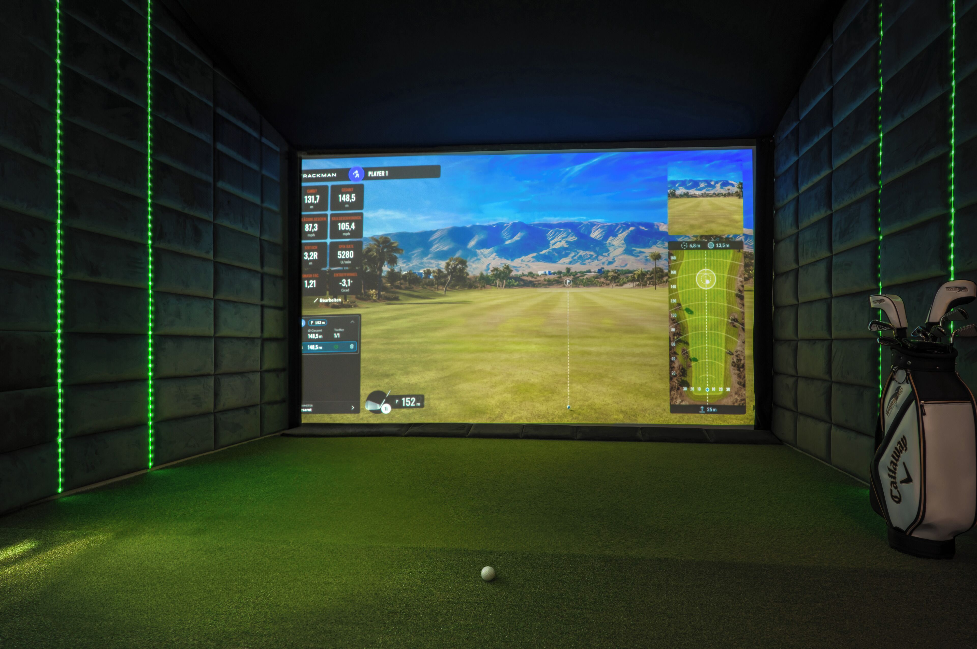 Een kamer met een groot scherm waarop een golfspel interface wordt getoond, een golfbag en groene sfeerverlichting.