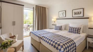 Une chambre d’hôtel avec un grand lit, un canapé, un bureau et une vue sur l’extérieur.