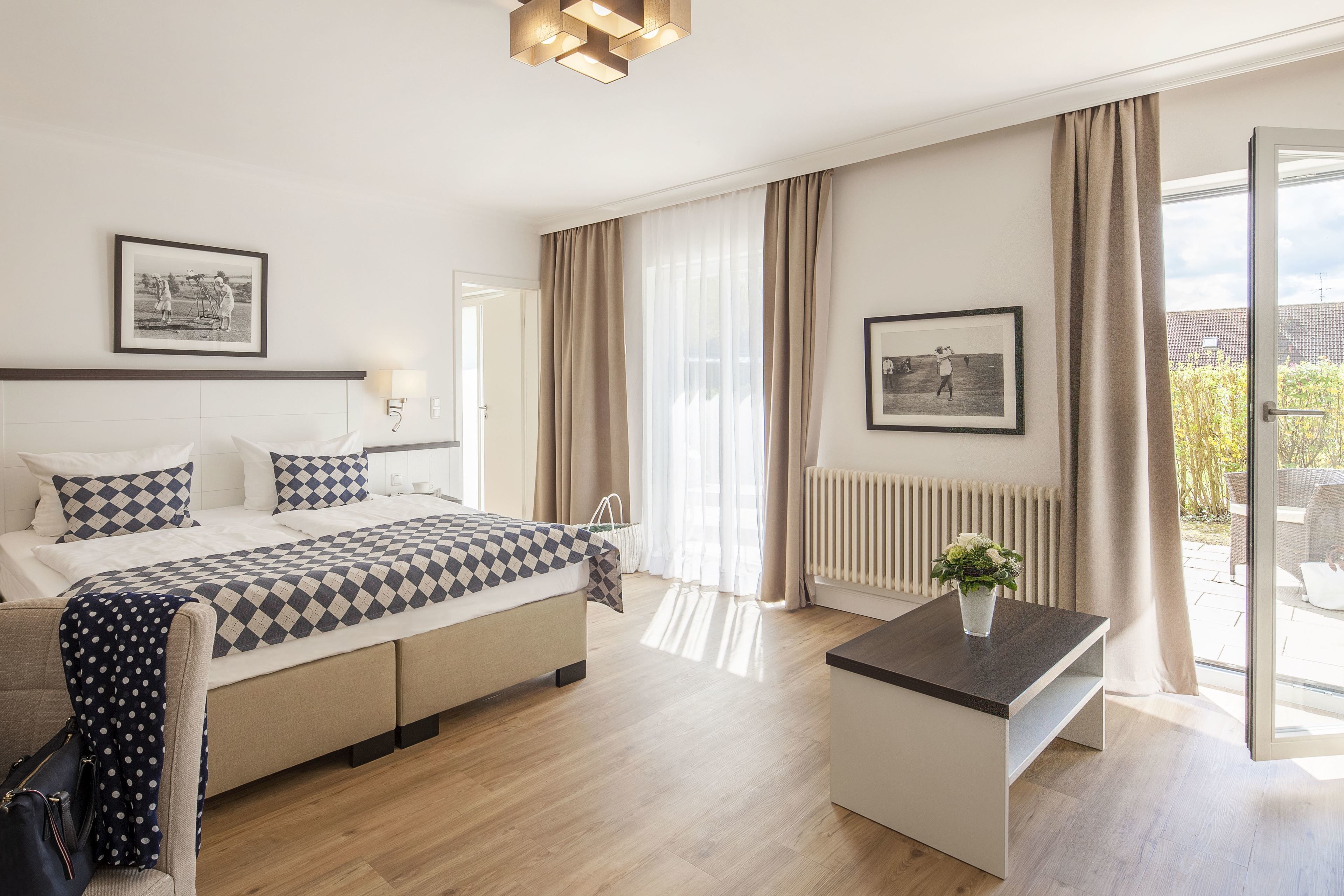 Ein modernes Hotelzimmer mit Bett, Nachttisch und Blick ins Freie.