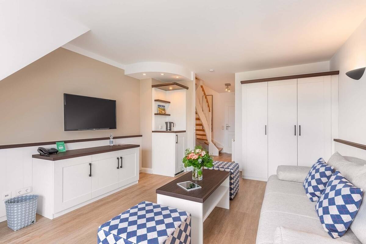 A modern apartment with a kitchen, living area, and a staircase.