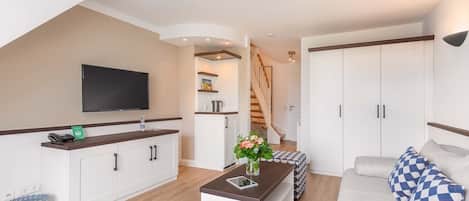 Um apartamento moderno com cozinha, sala de estar e escada.
