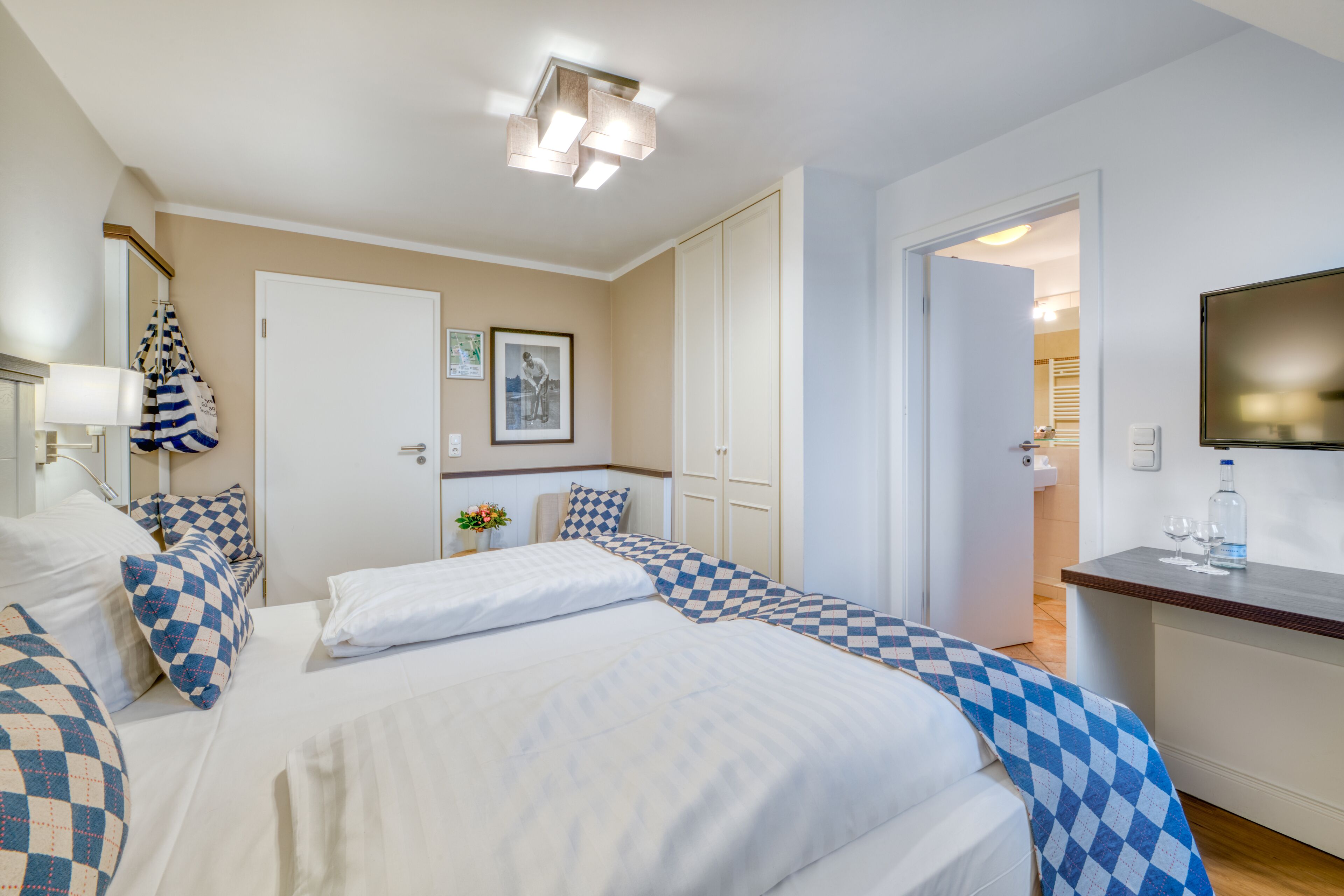 Une chambre d’hôtel avec deux lits, une salle de bain et un téléviseur.