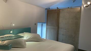 Un dormitorio moderno con cama, mesita de noche, escritorio y ventana con vistas.