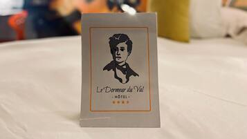 Une chambre d’hôtel avec un lit, un oreiller et un mur décoré d’œuvres d’art abstraites.