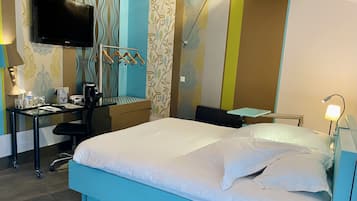 Une chambre d’hôtel équipée d’un lit, d’un bureau, d’une chaise et d’un téléviseur.