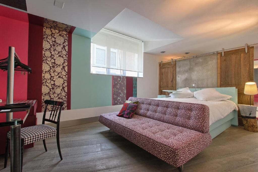 Un dormitorio con una cama, un sofá, un escritorio y una silla.