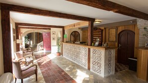 A hotel lobby with a reception desk, seating area, and a staircase leading to the upper floors. - Révész Hotel (Gyor)