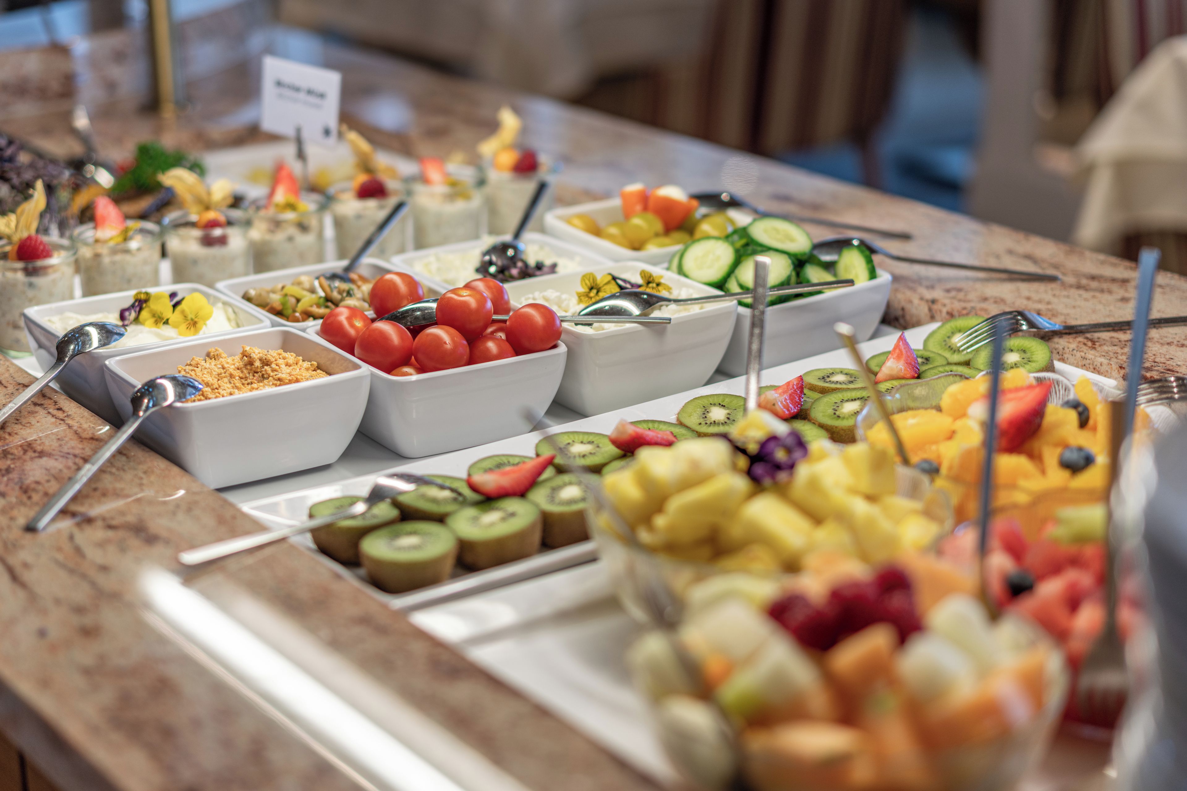 Een buffet met diverse eetopties, waaronder fruit, groenten en bereide gerechten.