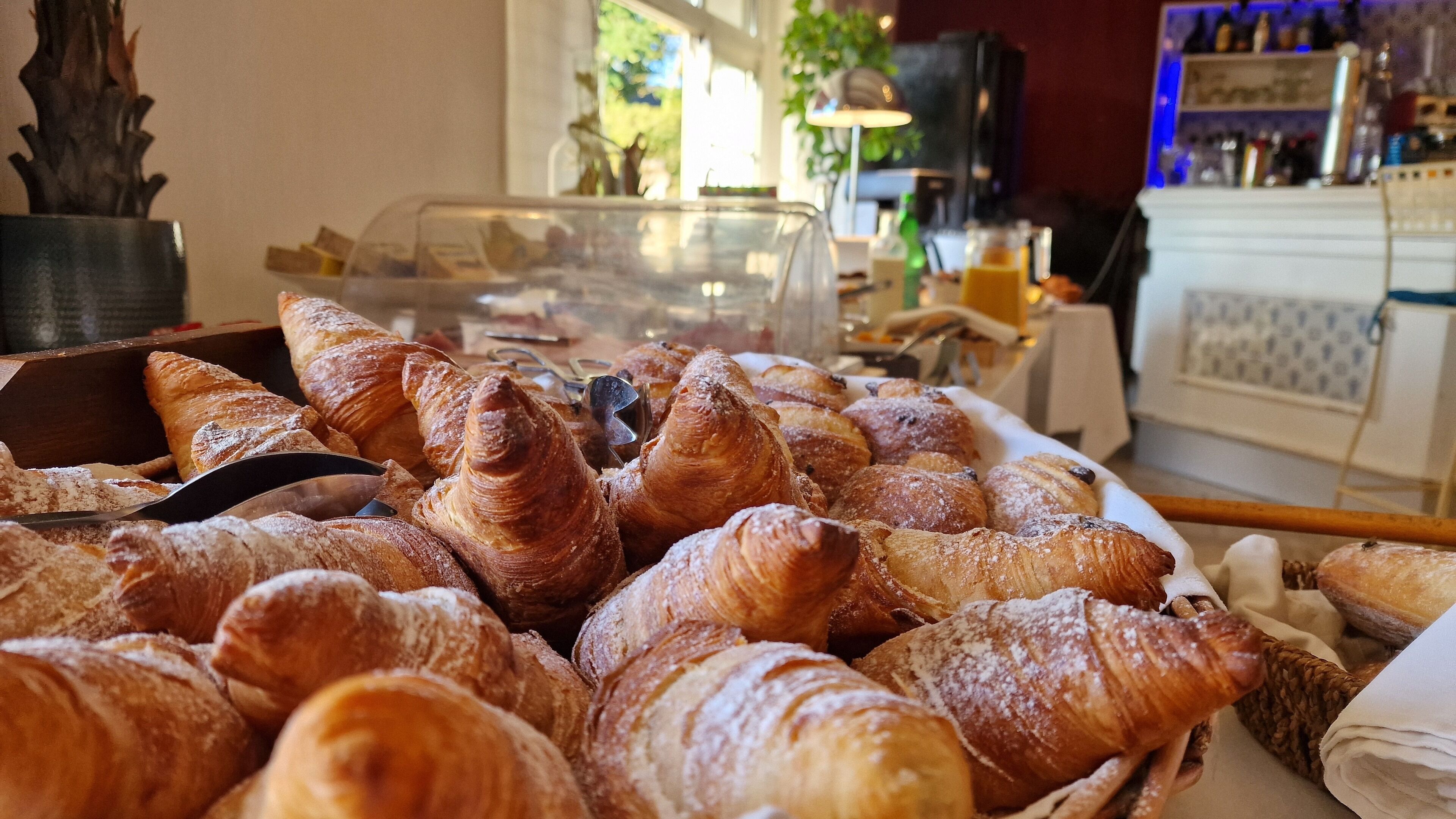 Une vitrine remplie de diverses pâtisseries, notamment des croissants, dans une boulangerie.