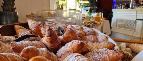A display of assorted pastries, including croissants, in a bakery setting.
