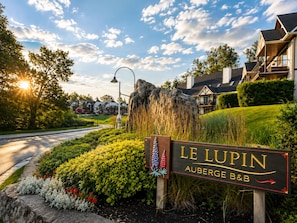A sign for Le Lupin Auberge B&B with a landscaped garden in front. - Auberge Le Lupin-Self Check-in (Mont-Tremblant)