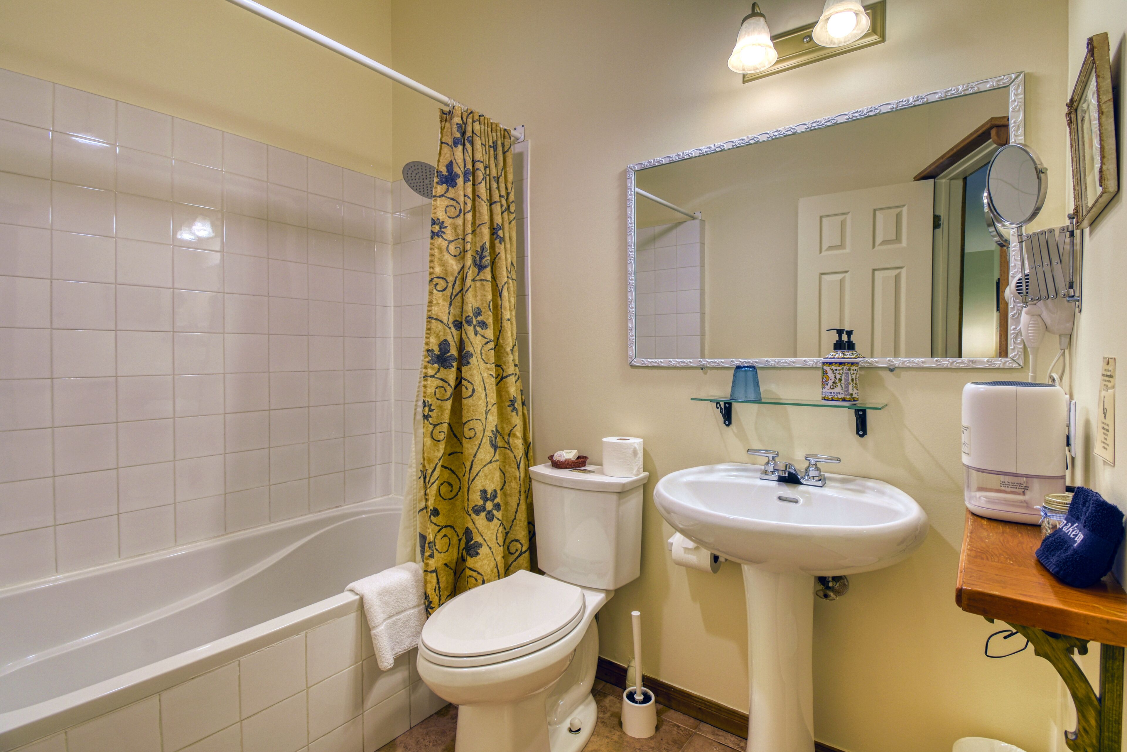 Une salle de bain équipée d’une baignoire, de toilettes, d’un lavabo et d’un miroir.