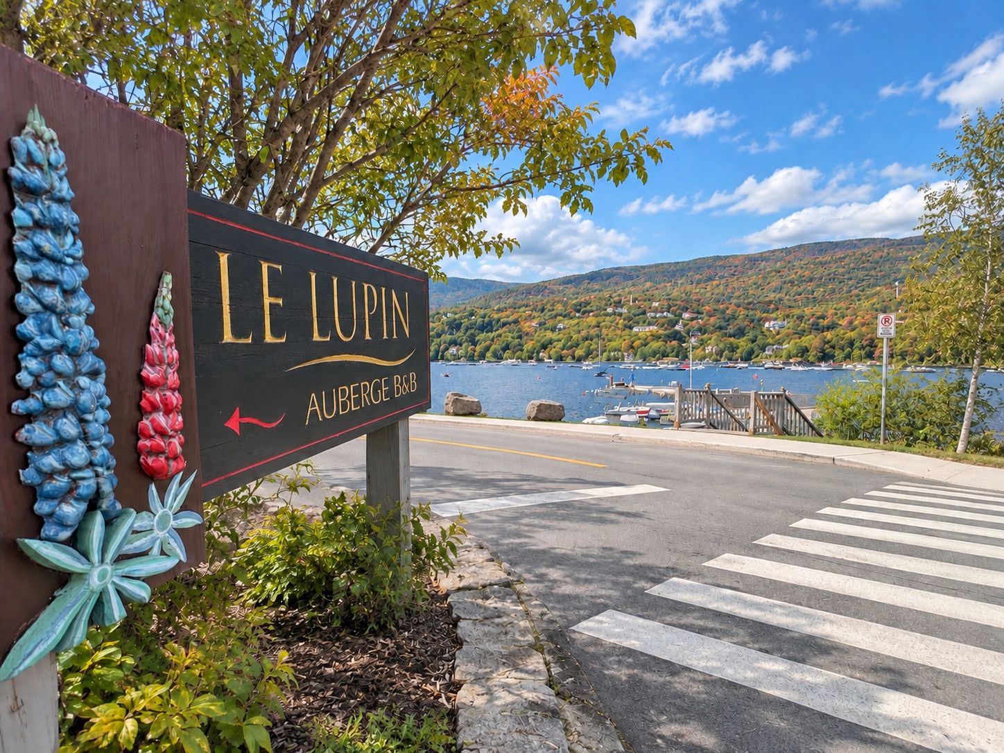 Señal para Le Lupin Auberge B&B con vista a un lago y barcos.