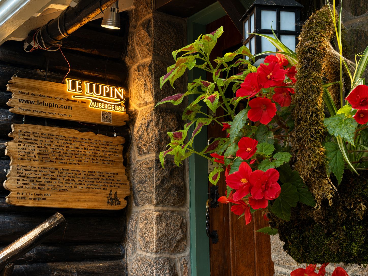 A wooden sign with room information for Le Lupin B&B, including a website URL and a WiFi code.