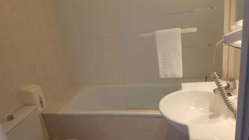 A bathroom with a bathtub, a sink, and a toilet.
