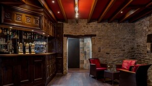 Un espace bar agrémenté de meubles en bois et d’un mur en pierre servant de décor.