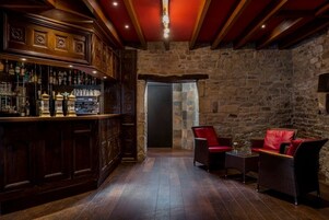Uma área de bar com armários de madeira e um fundo de parede de pedra.