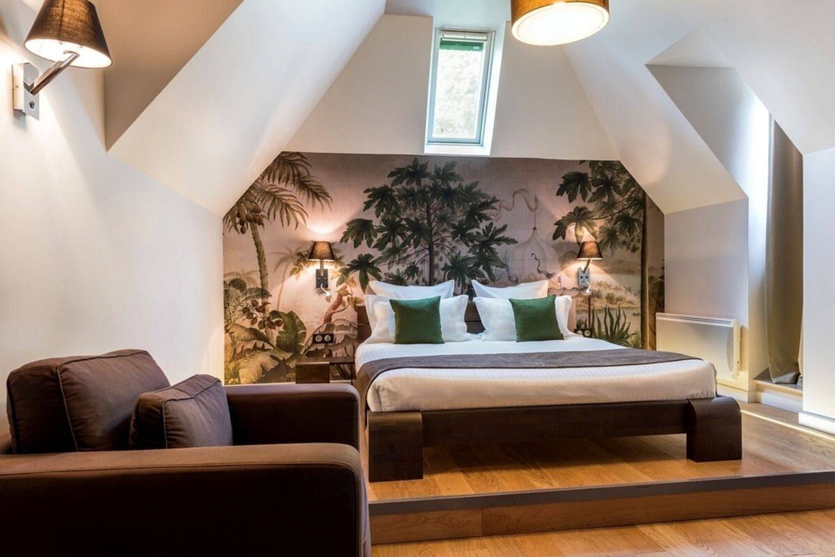 Un dormitorio con cama, sofá marrón y un mural en la pared.