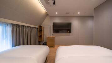 A modern hotel room with two beds, a flat-screen TV mounted on the wall, a wooden nightstand, and a built-in shelf.