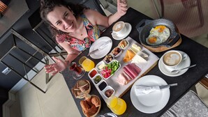 Una mesa de comedor con alimentos para el desayuno, incluyendo huevos, queso, pan y bebidas.