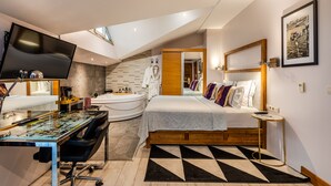 Un dormitorio moderno con cama, escritorio y ventana grande.