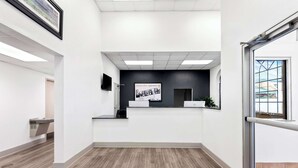A reception area with a reception desk, a mounted television, and a framed picture on the wall.