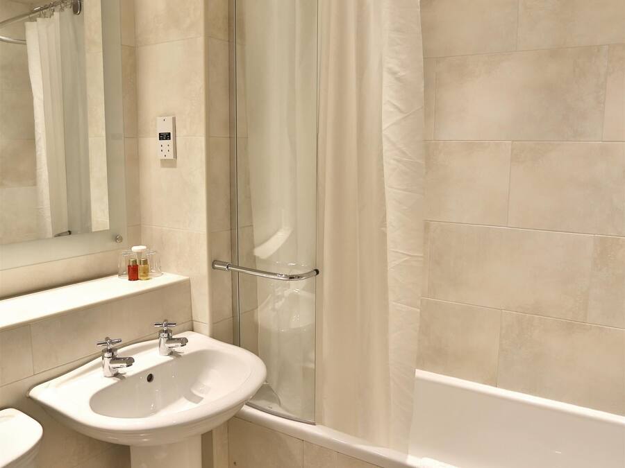 Ein Badezimmer mit Waschbecken, Toilette, Badewanne und Duschvorhang.