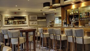 A bar area with high stools, a bar counter, and a mirror. - Best Western Motherwell Centre Moorings Hotel (Motherwell)