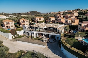 Un resort moderno con bar en la azotea, piscina y vistas a la colina.