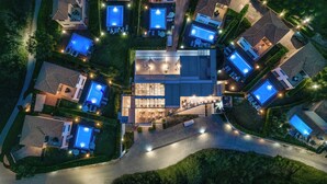 An aerial view of a residential area with multiple houses, each featuring a swimming pool and outdoor seating areas. - St. John Villas Zakynthos (Zakynthos)