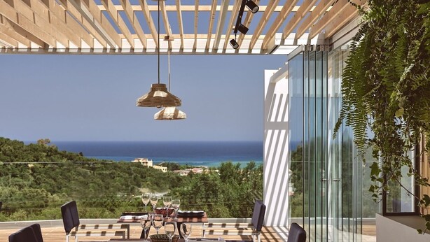 A terrace with a table set for dining, overlooking a coastal landscape. - St. John Villas Zakynthos (Zakynthos)