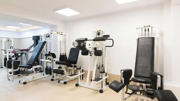 A gym with various exercise machines, including a leg press and a chest press.