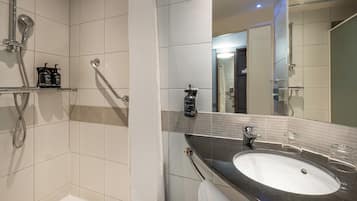 A modern bathroom with a bathtub, a shower, a sink, and a mirror.