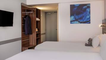 Une chambre d’hôtel avec un lit, une armoire, un tableau et un téléviseur.