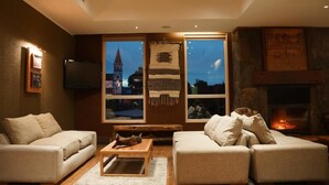 A cozy living room with two sofas, a coffee table, and a fireplace. - Solace Hotel Puerto Varas (Puerto Varas)