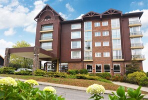 A hotel with a brown facade, multiple balconies, and a covered entrance. - Solace Hotel Puerto Varas (Puerto Varas)