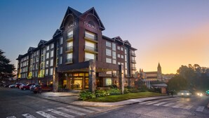 A multi-story hotel with a prominent entrance, balconies, and a well-lit facade. - Solace Hotel Puerto Varas (Puerto Varas)