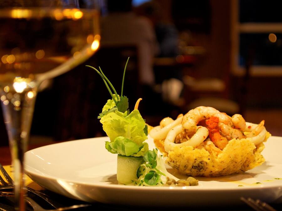 A plate of food with a glass of wine.