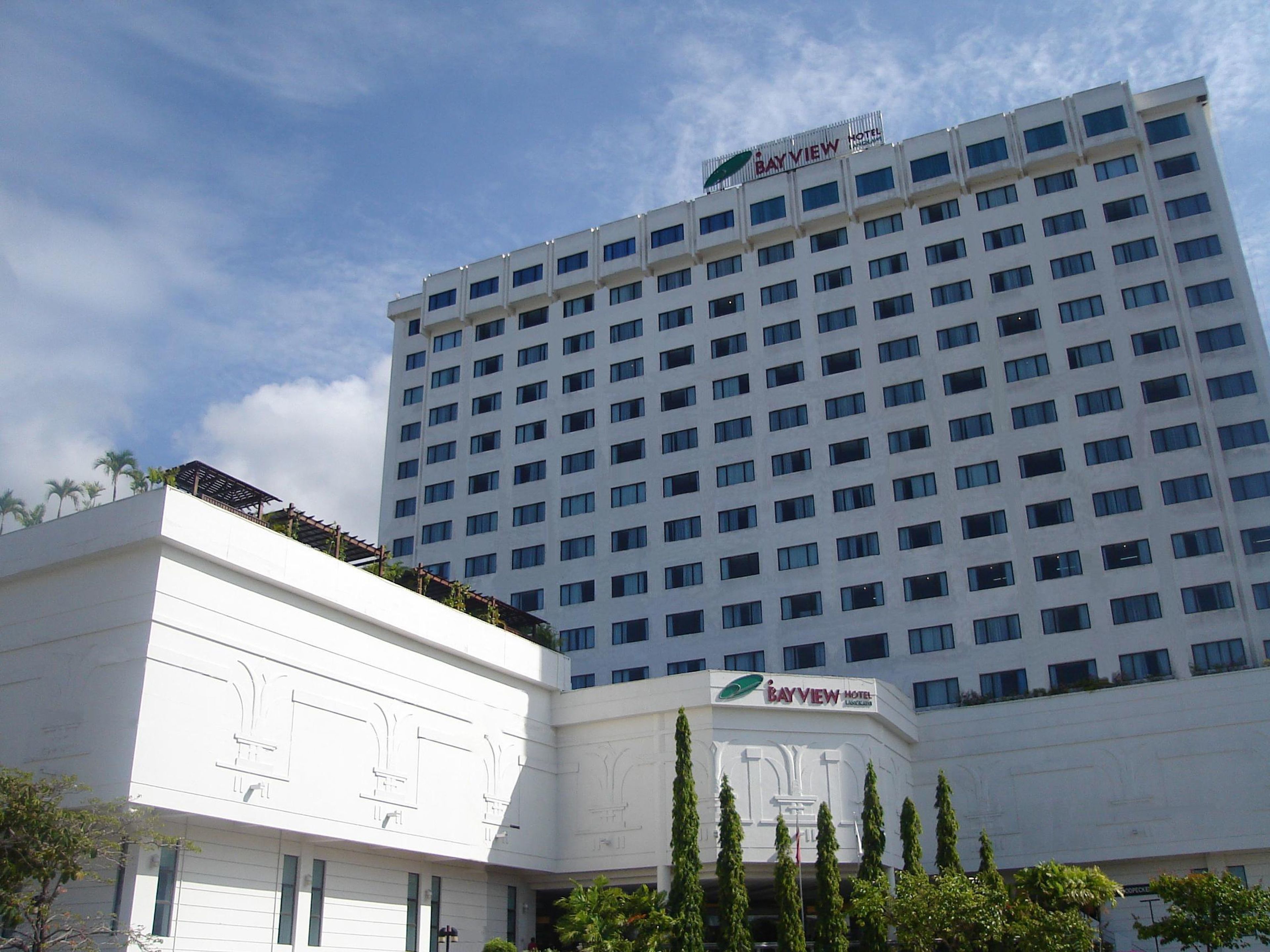 Ein mehrstöckiges Hotelgebäude mit einem gut sichtbaren Schild mit der Aufschrift 'Bayview Hotel' auf der Spitze.