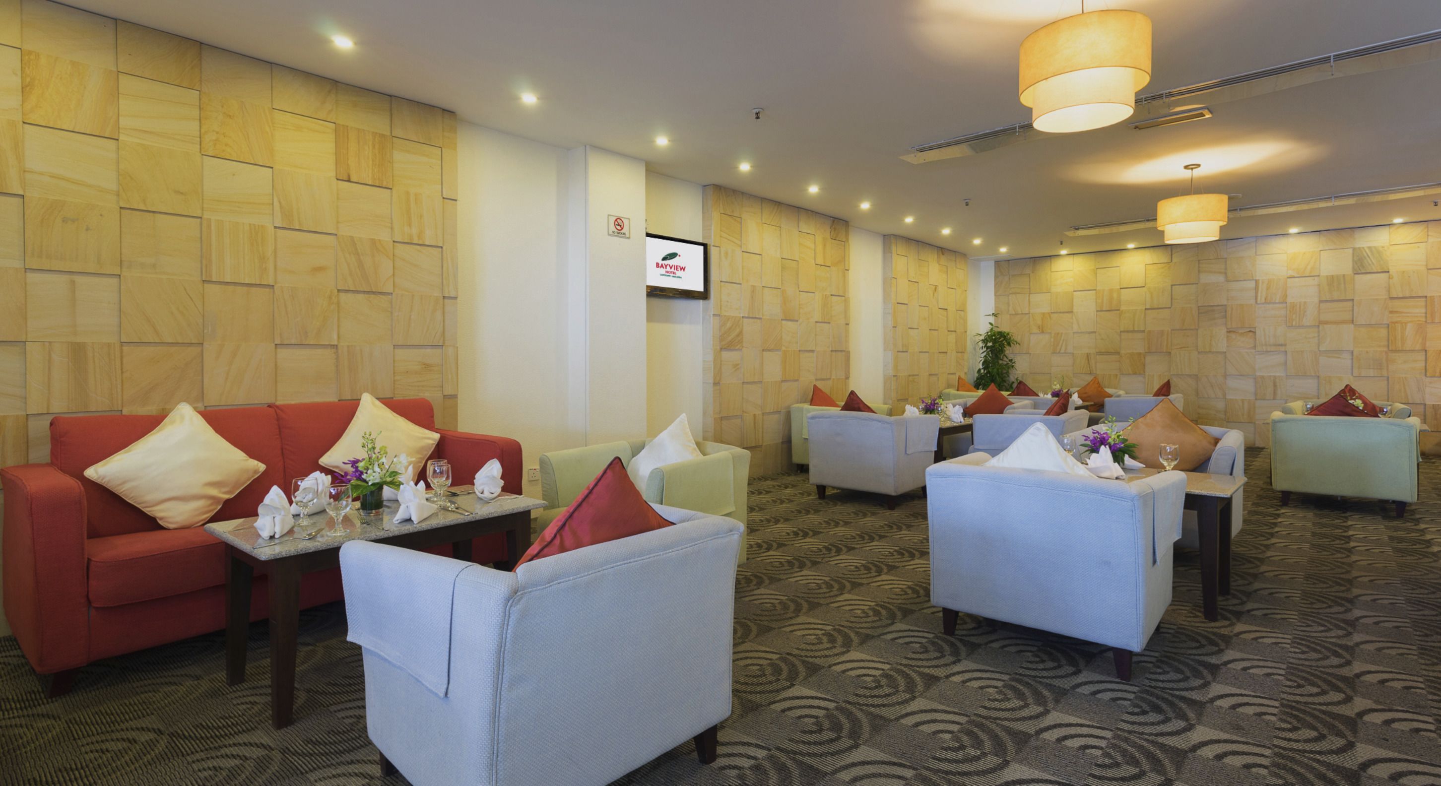 A hotel lobby with multiple seating areas, including sofas and armchairs, arranged in a spacious layout.