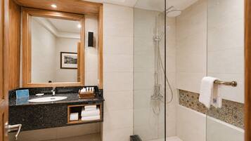 A modern bathroom with a glass-enclosed shower, a vanity with a sink, and a large mirror.