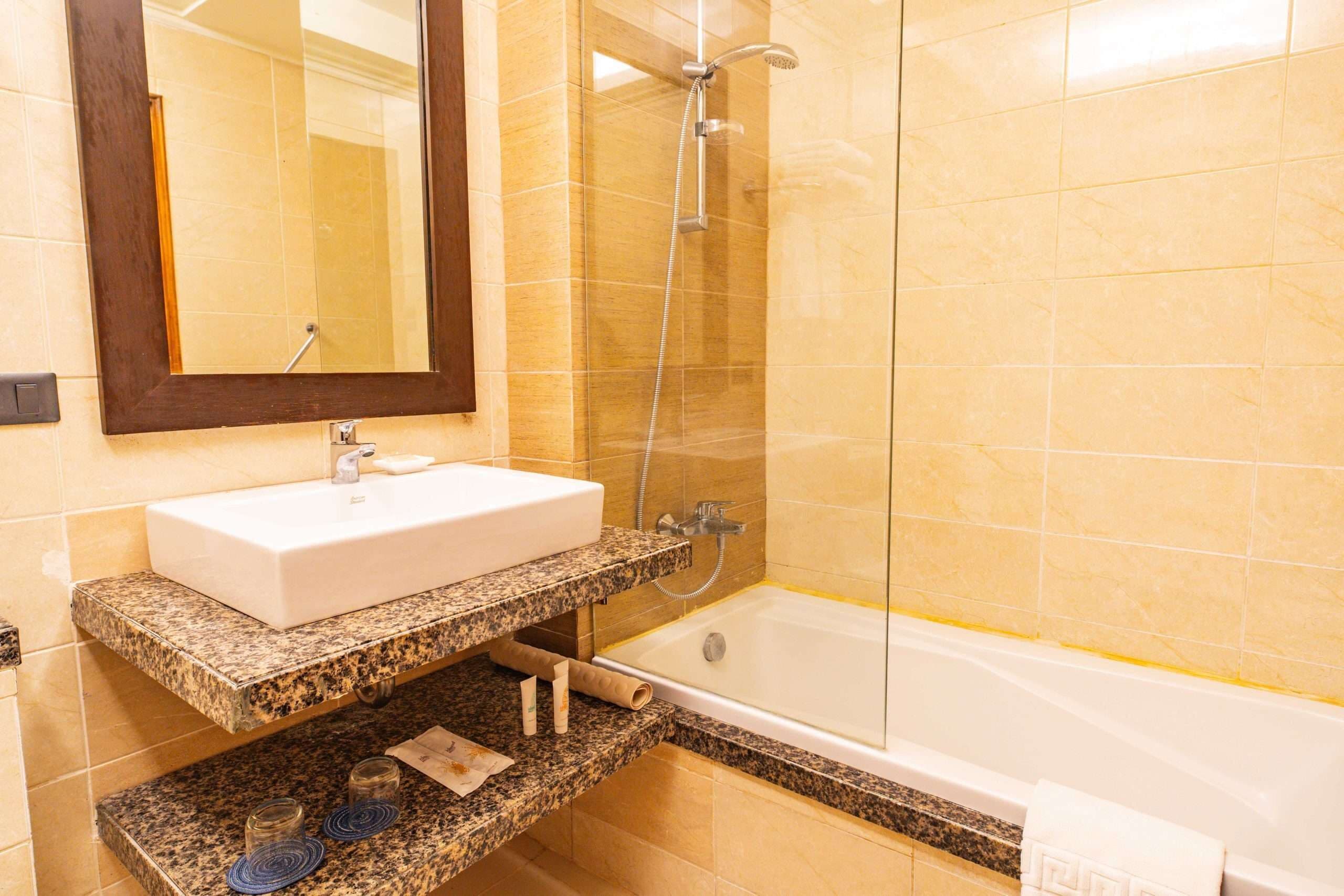 A bathroom with a white sink, a mirror, a shower, and a bathtub.
