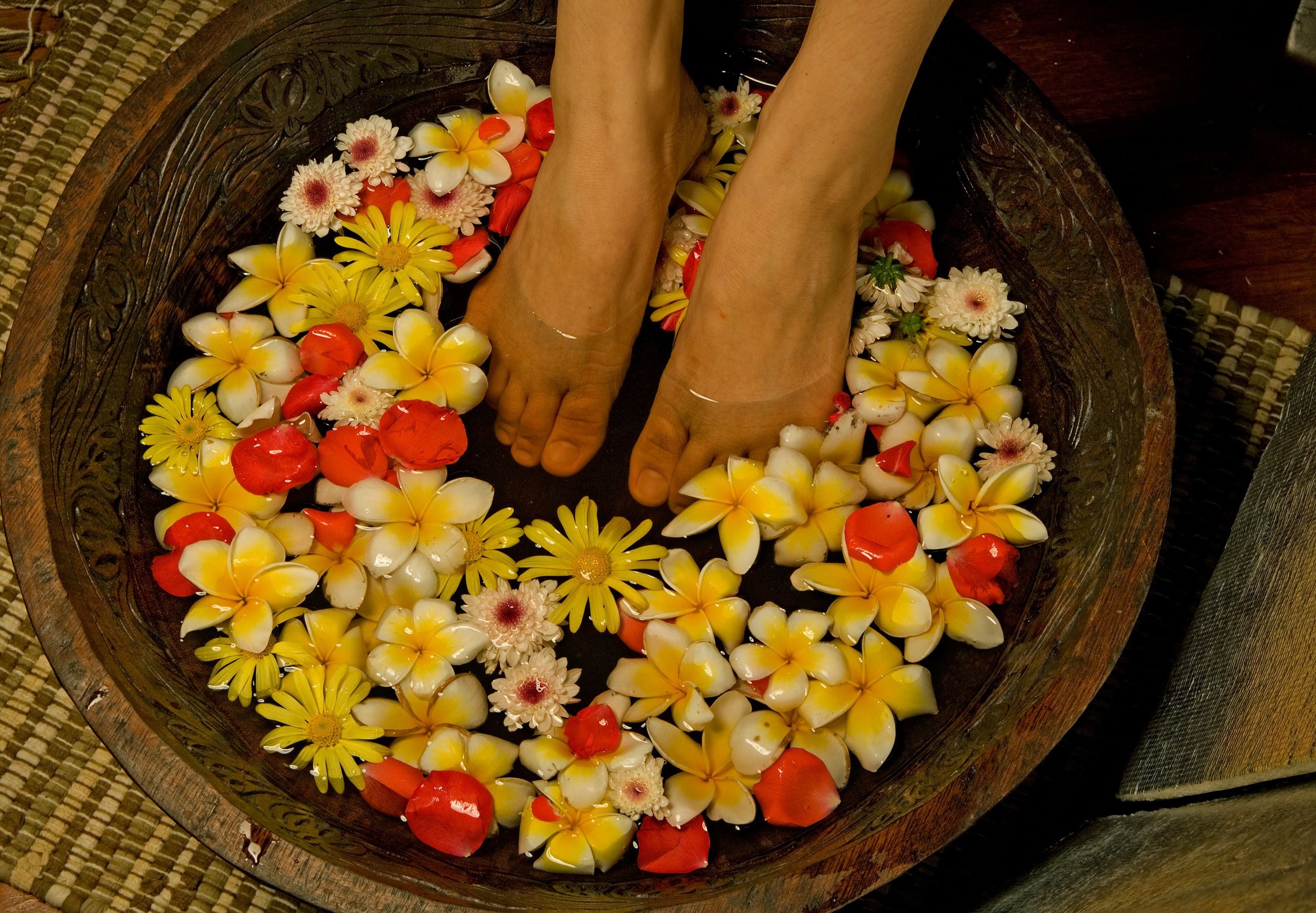 A wooden bowl filled with water and flowers.