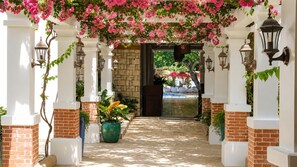 An entrance with a brick archway, potted plants, and outdoor seating. - Costabella Tropical Beach Hotel (Lapu-Lapu)