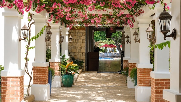 An entrance with a brick archway, potted plants, and outdoor seating.