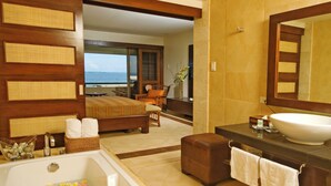 Une salle de bain avec une grande baignoire, un lavabo et un miroir.