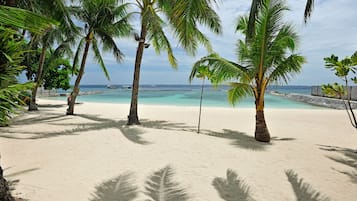 Plage privée, sable blanc, chaises longues, serviettes de plage