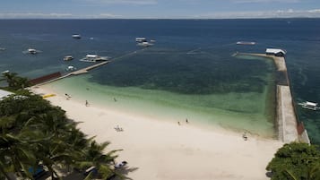Privat strand, hvit sand, solsenger og strandhåndklær