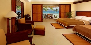 Enjoy ocean views from the comfort of this room, featuring a large bed, seating area, and access to the outdoors.